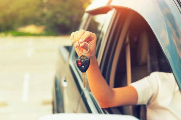 Женщины, покупающие новый автомобиль, держат ключи от машины